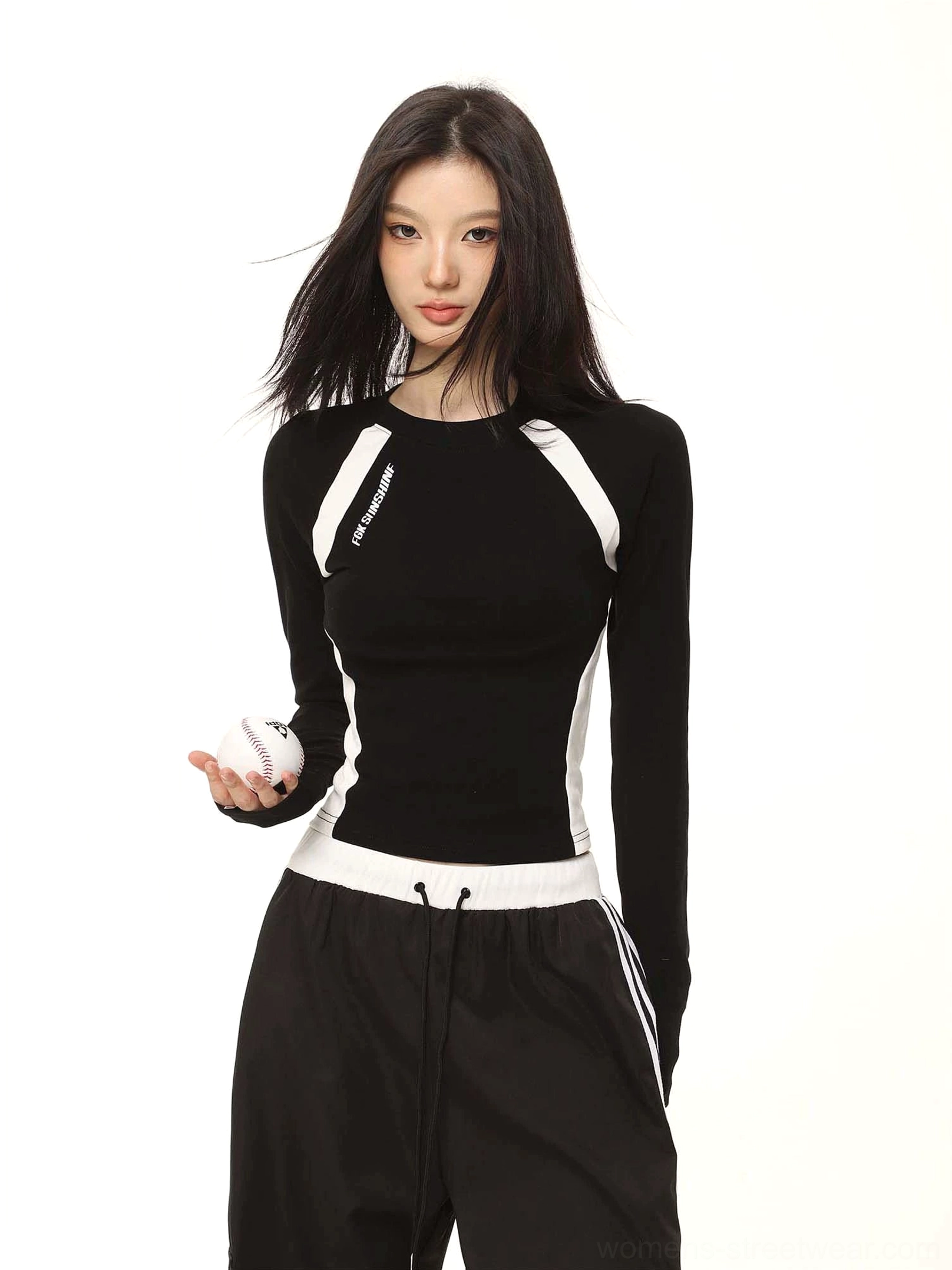 Black contrast raglan cropped long sleeve top with white color-block trim styled with black cargo pants and baseball prop