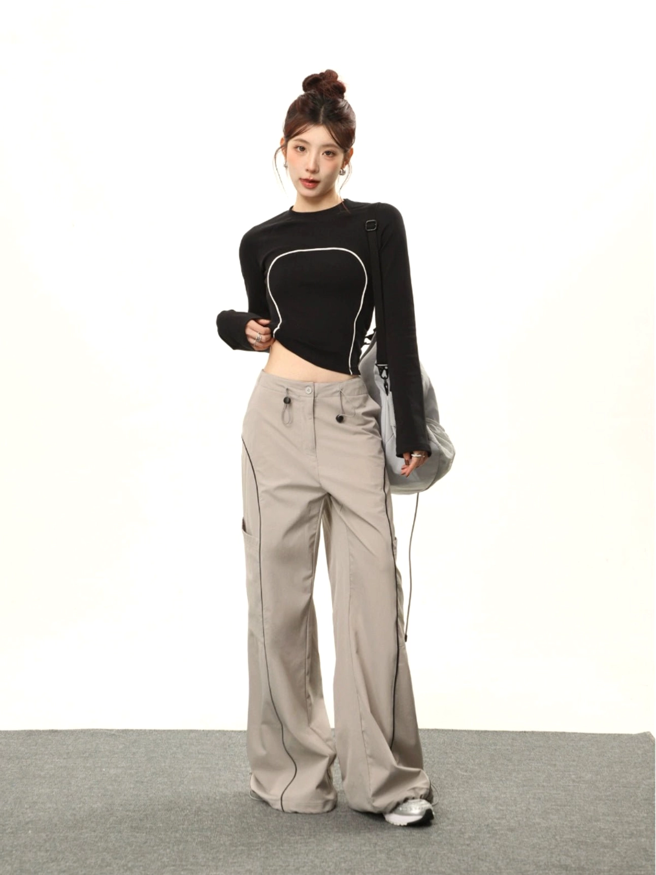 Black contrast stitch cropped long sleeve streetwear top with white curved seams front full body view