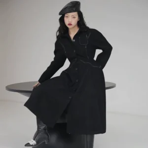 Black contrast stitch shirt dress shown in a full-length side-front view with tailored waist, button front, chest flap pocket, and A-line midi skirt