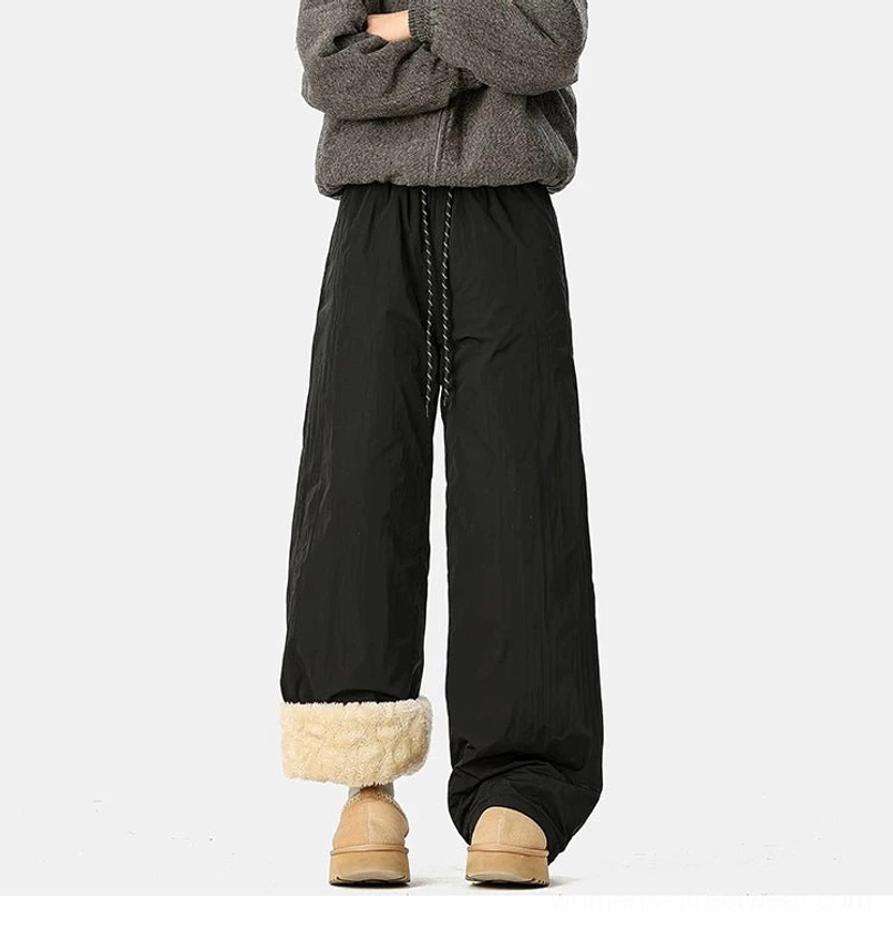 Back view of black convertible fleece-lined wide-leg pants with rolled shearling cuffs, drawstring waist, and relaxed fit