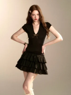 Black coquette tiered ruffle mini dress with bow detail shown in a three-quarter front studio view
