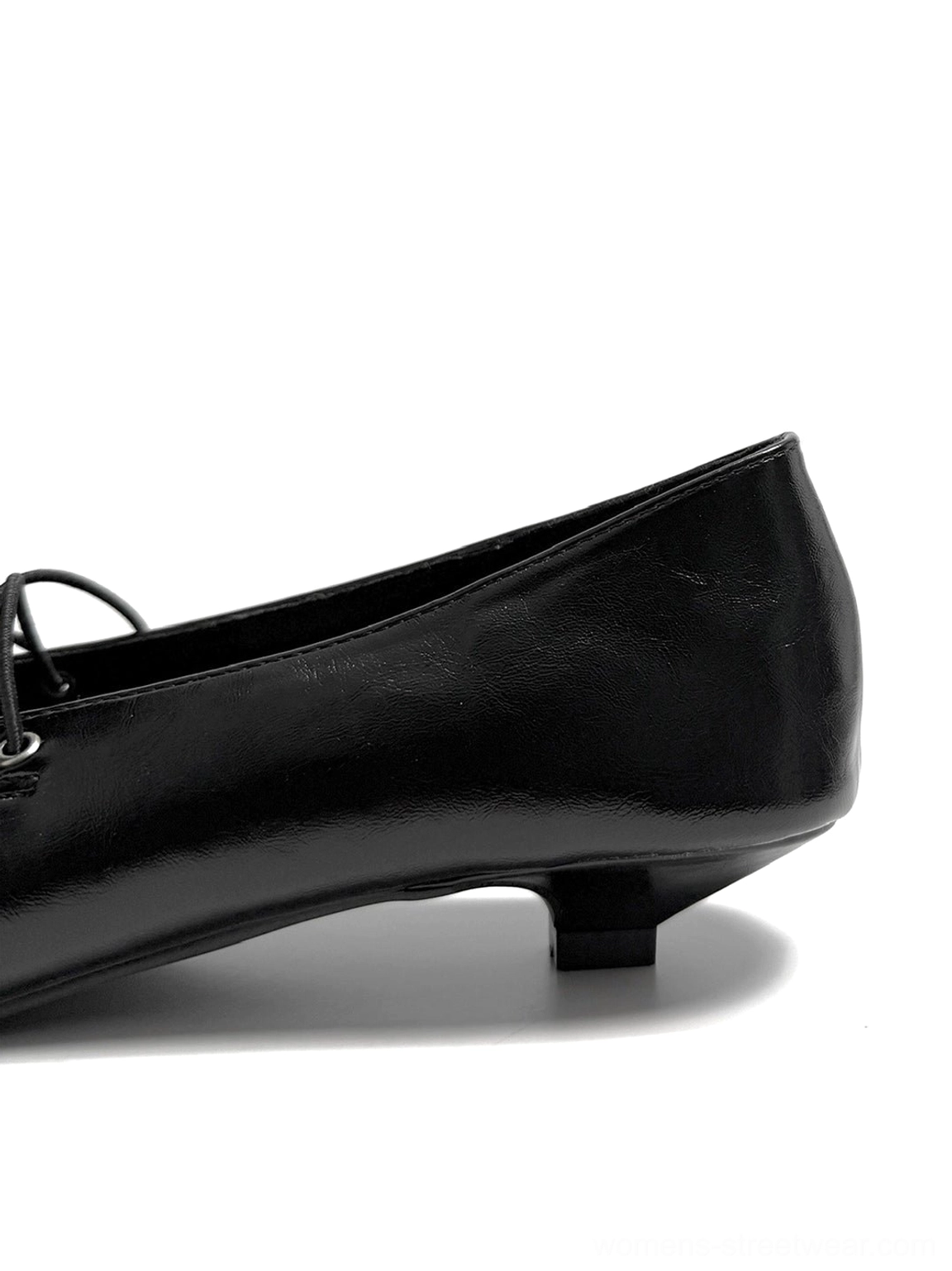 Black corset-lace pointed ballet flats with glossy leather-look finish and low kitten heel for modern streetwear outfits