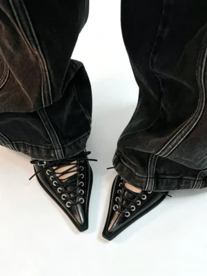 Black corset lace pointed Mary Jane wedge pumps worn with dark wash wide-leg denim in an overhead streetwear styling view