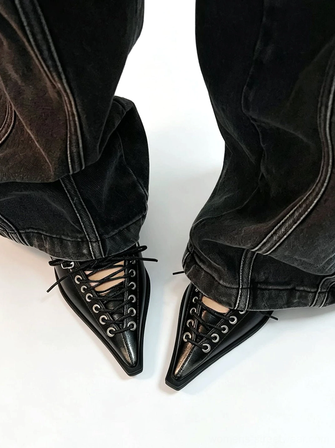 Black corset lace pointed Mary Jane wedge pumps worn with dark wash wide-leg denim in an overhead streetwear styling view