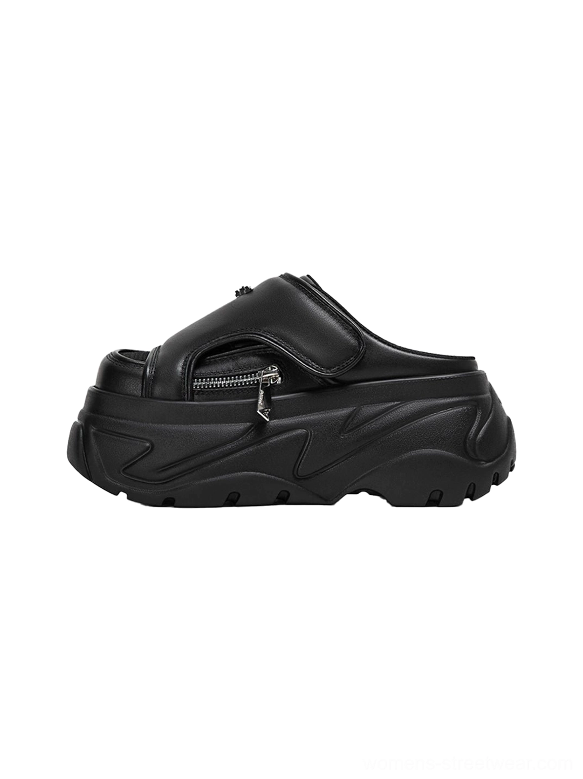 Black covered-toe chunky platform slide sandal shown in left side profile with matte textured upper, silver zipper detail, thick rugged outsole, and slip-on mule construction