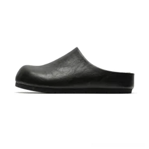 Black cracked leather closed-toe mule clogs shown in left side profile with rounded toe, open back, flat sole, and minimalist streetwear silhouette