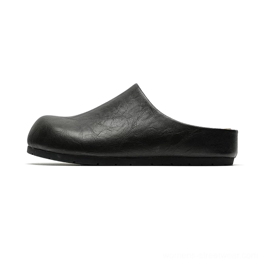 Black cracked leather closed-toe mule clogs shown in left side profile with rounded toe, open back, flat sole, and minimalist streetwear silhouette
