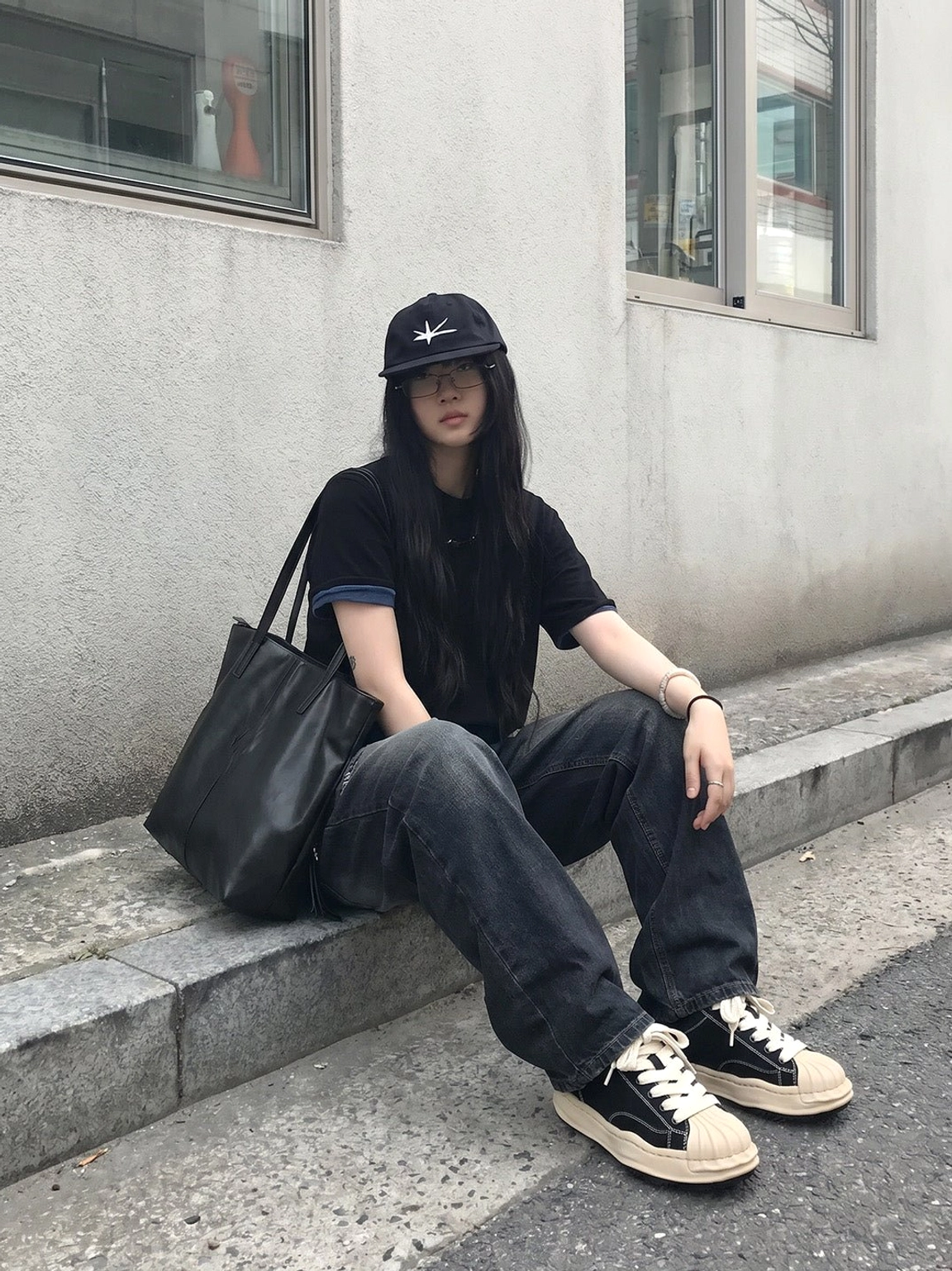 Black and cream 7cm platform court sneakers worn with an all-black streetwear outfit on outdoor concrete steps