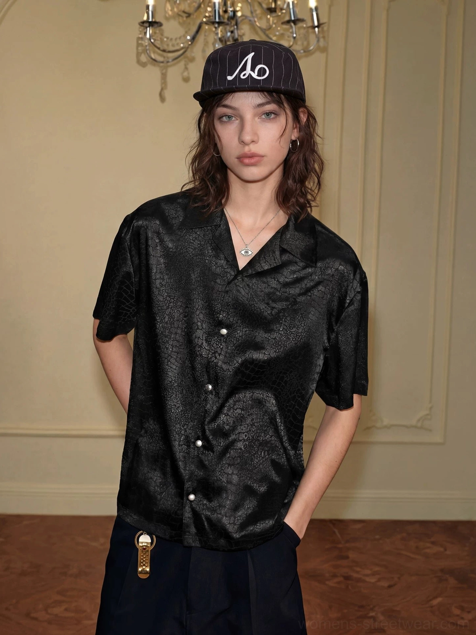 Front full-body view of a black crocodile jacquard satin short sleeve streetwear shirt with relaxed fit, open camp collar, and glossy textured fabric