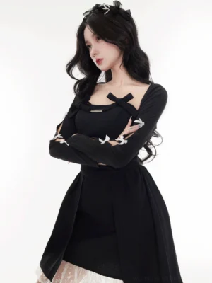Black cropped bow cardigan styled with a square neckline, hollow-out sleeves, white bow details, and an asymmetrical lace-layered hem