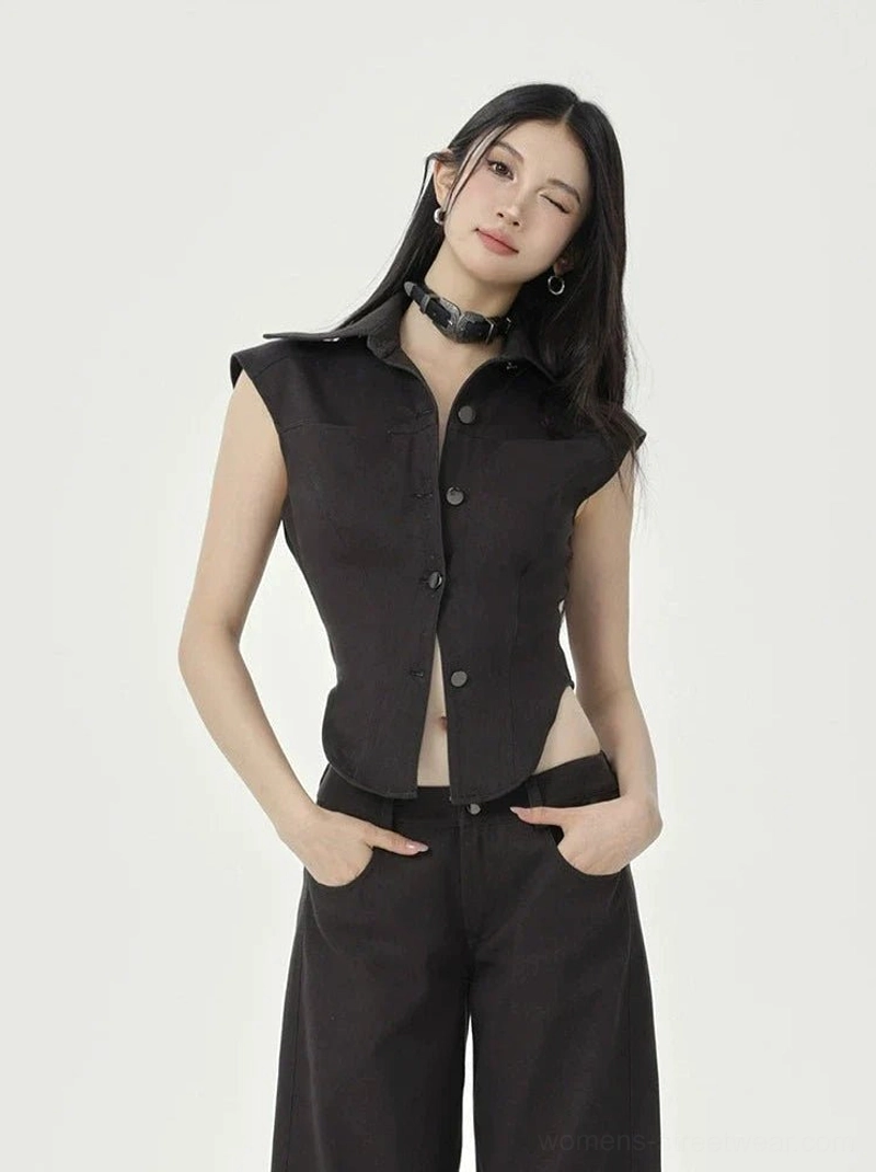 Black cropped collared button-up top with asymmetric curved hem styled with black wide-leg pants in studio