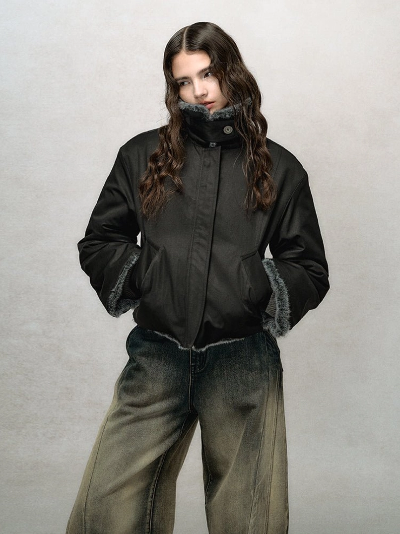 Black cropped faux fur bomber jacket styled with washed wide-leg jeans, stand collar, zip front, fur cuffs, and side pockets