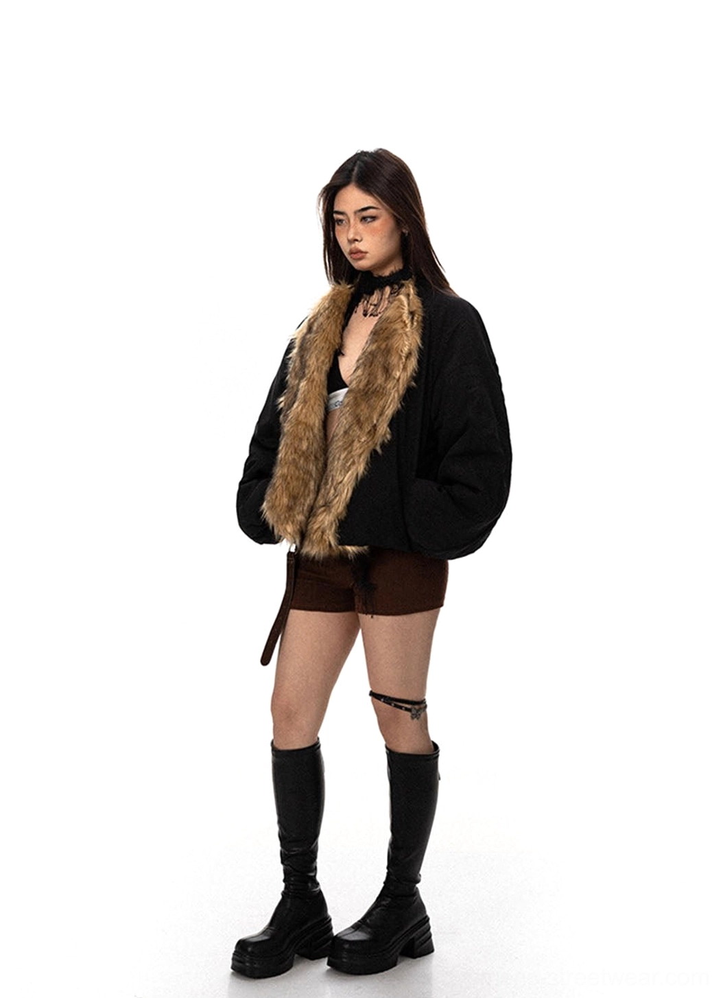 Black cropped flight jacket with wide brown faux fur collar styled with low rise shorts platform boots and belt detail