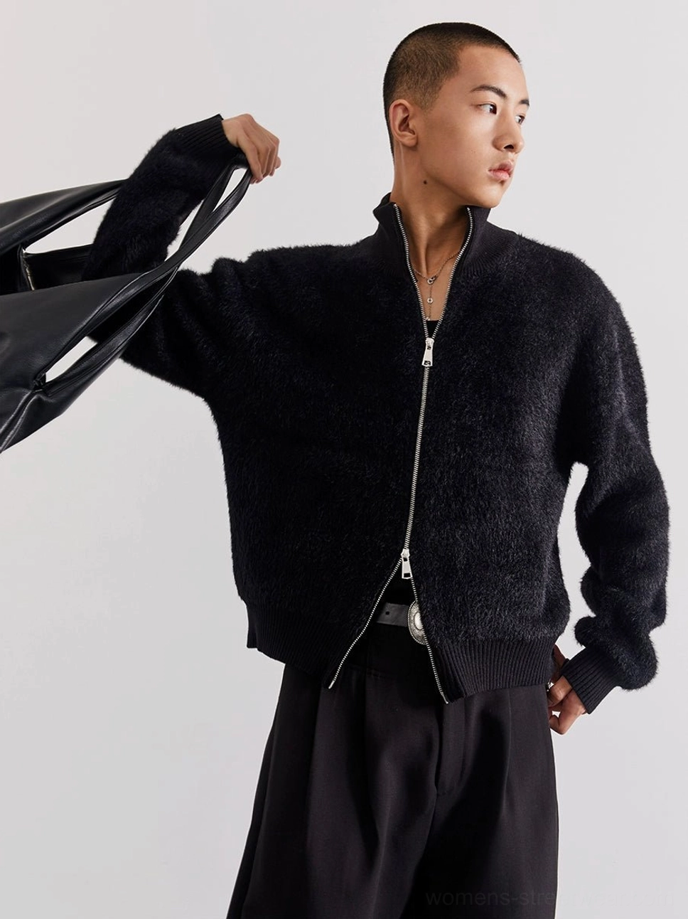 Black cropped fuzzy fleece cardigan with stand collar and exposed silver zipper in three-quarter studio view