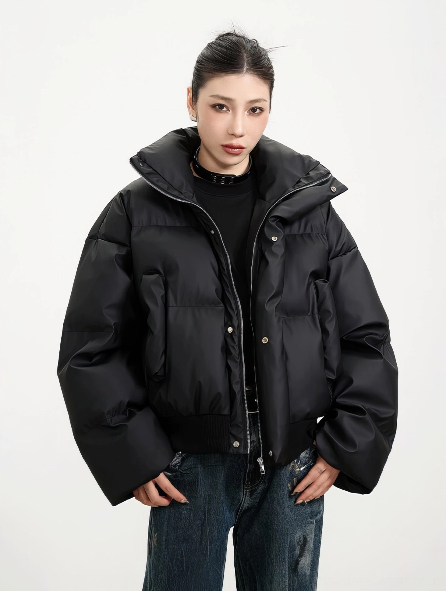 Black cropped puffer winter jacket with fold-over stand collar zipper snap closure and relaxed drop shoulder silhouette