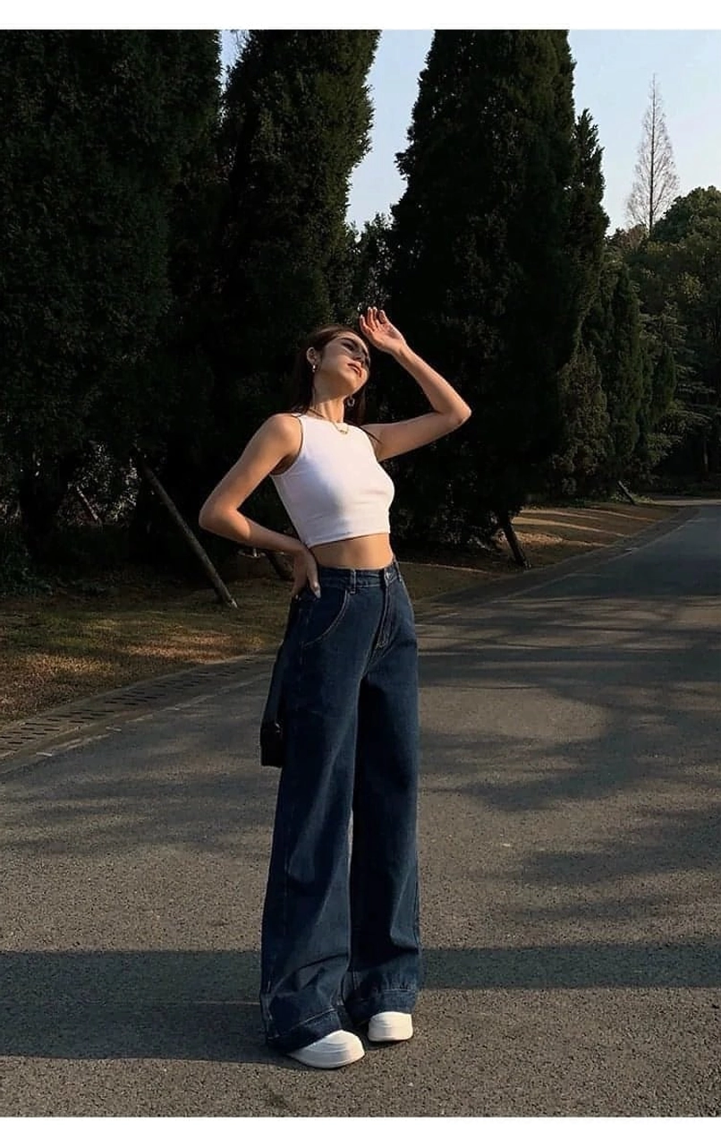 Black cropped tank top monochromatic ensemble - matching similarly-toned bottoms with chunky silver jewelry structured handbag and bold sunglasses for streamlined silhouette