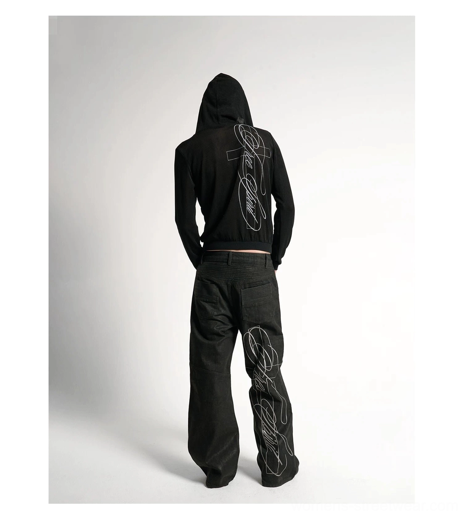 Black cross script zip-up hoodie back view paired with matching track pants on male model in studio