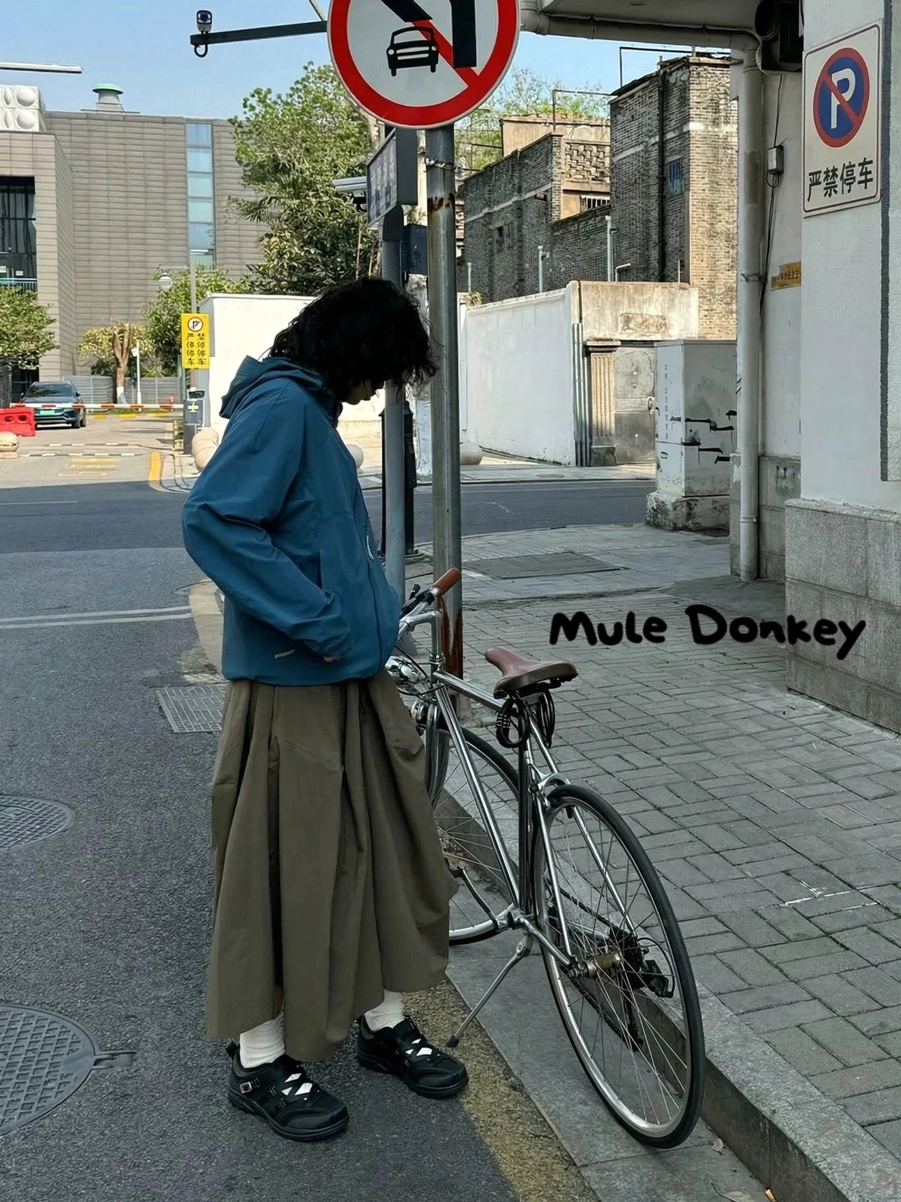 Urban layered streetwear outfit featuring black cross-strap cutout sneakers with white ankle socks for relaxed gender-neutral city style