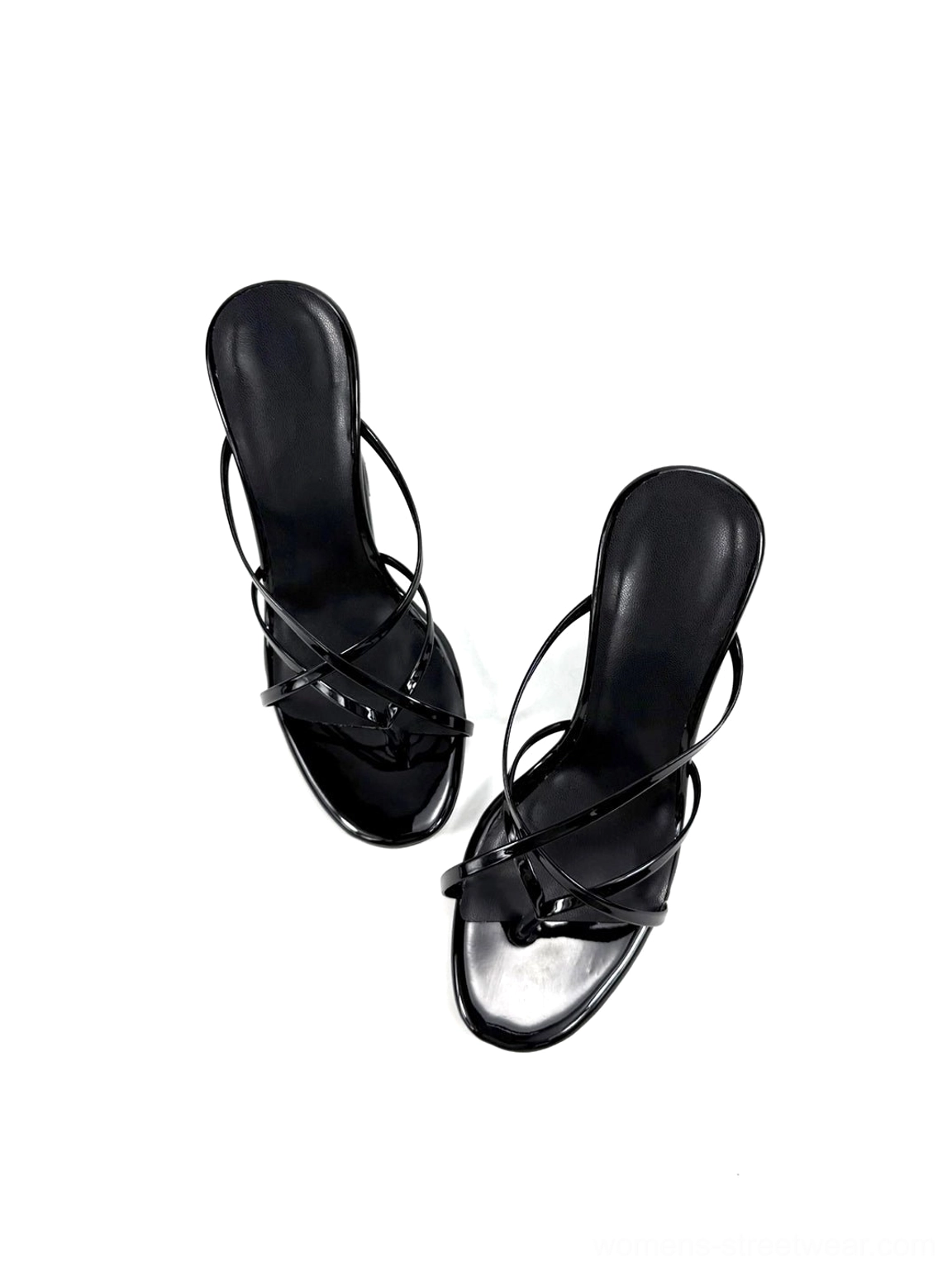 Angled studio view of black patent-look mule sandals with thin crisscross straps and sculptural wedge heels