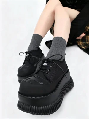 Model wearing black cross toe chunky platform lace-up shoes with gray crew socks in a front overhead streetwear styling view