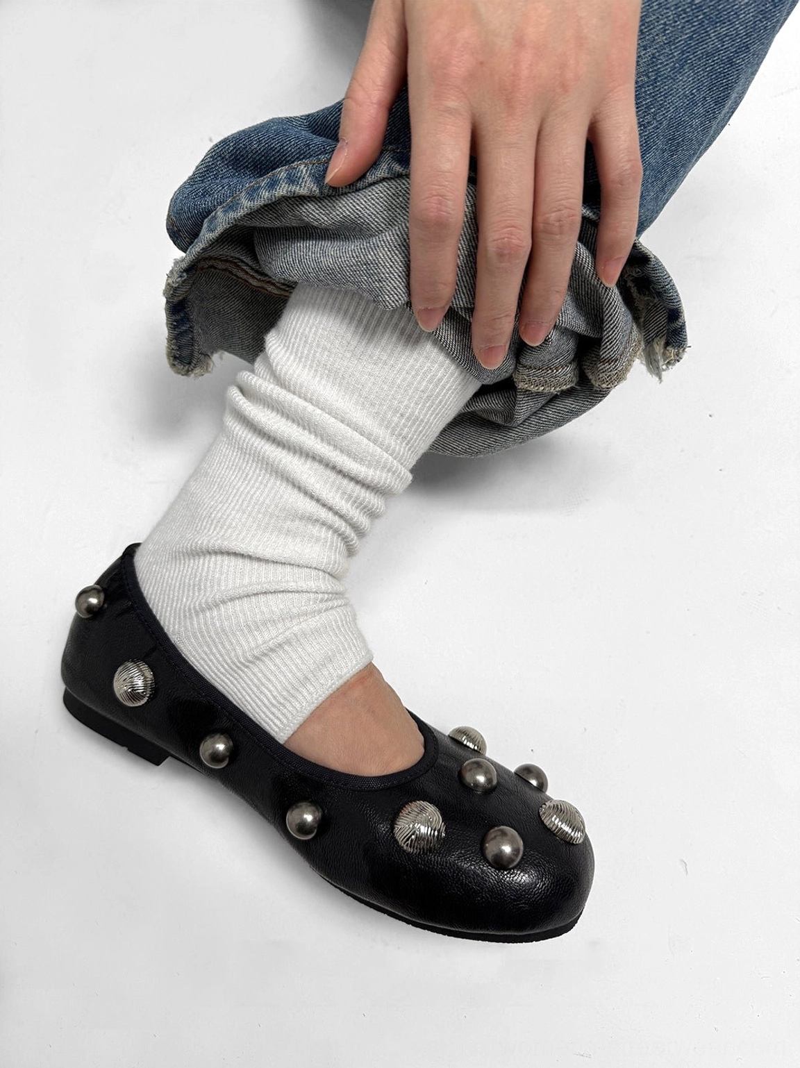 Black crystal stud ballet flat styled with white slouch socks and rolled blue denim jeans in a casual Seoul streetwear outfit