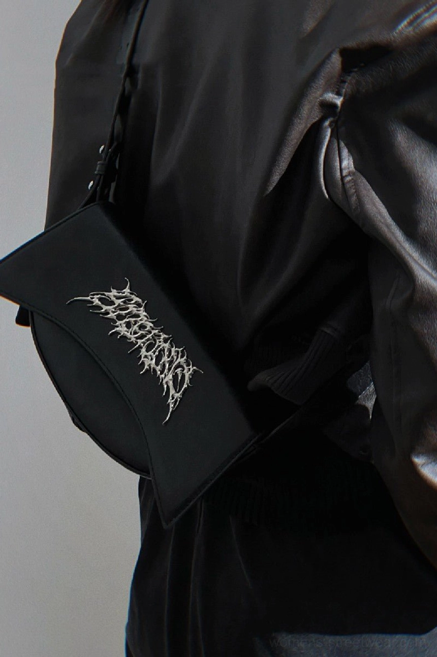 Black curved gothic PU leather shoulder bag worn over a dark leather jacket with full silhouette visible