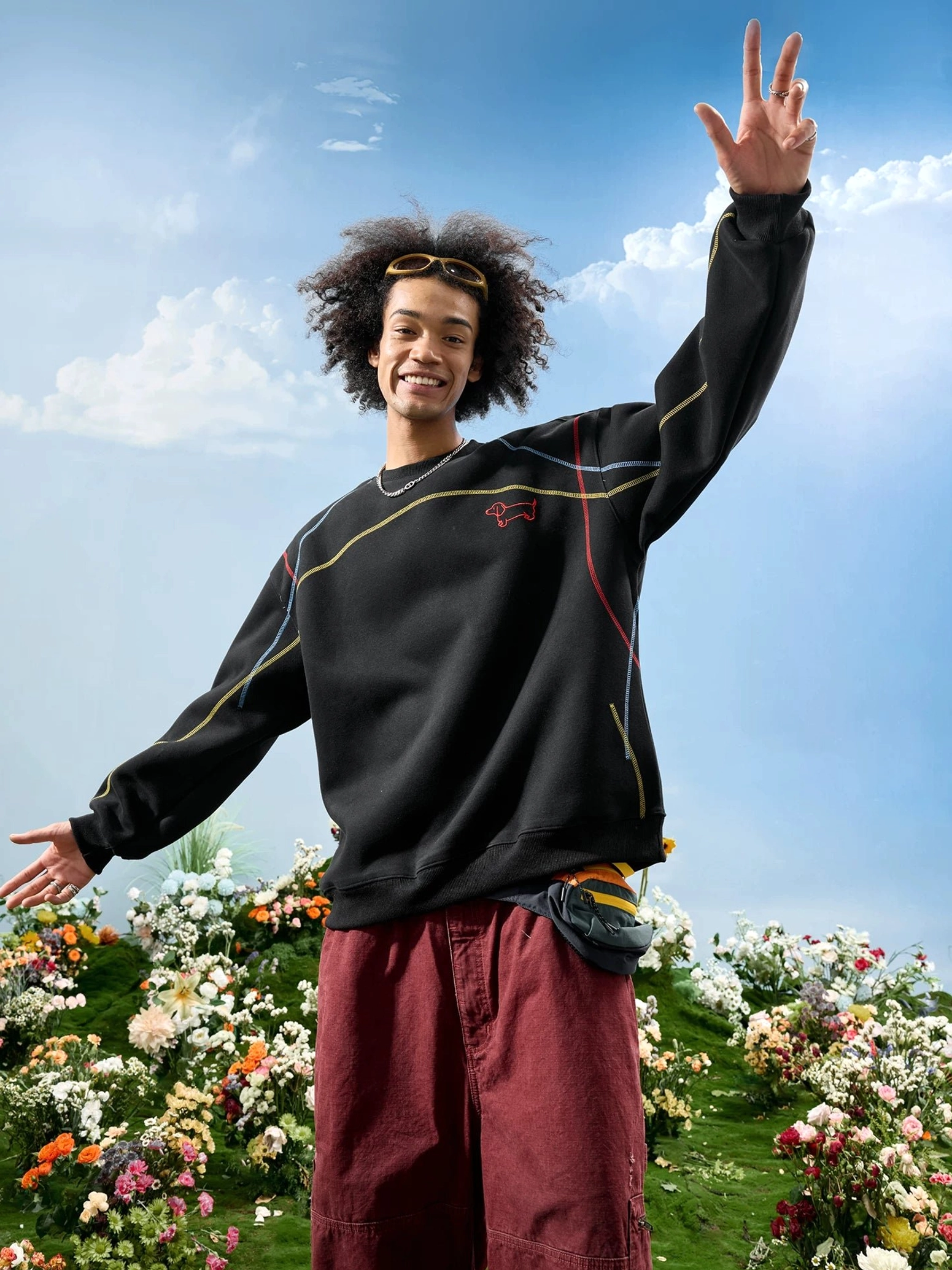 Black dachshund embroidered oversized crewneck sweatshirt with red chest embroidery and colorful shoulder stitching worn by a male model