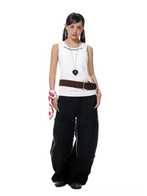 Black deconstructed patchwork wide-leg streetwear pants with raw frayed square panels, drawstring elastic waist, and oversized relaxed fit shown on a female model