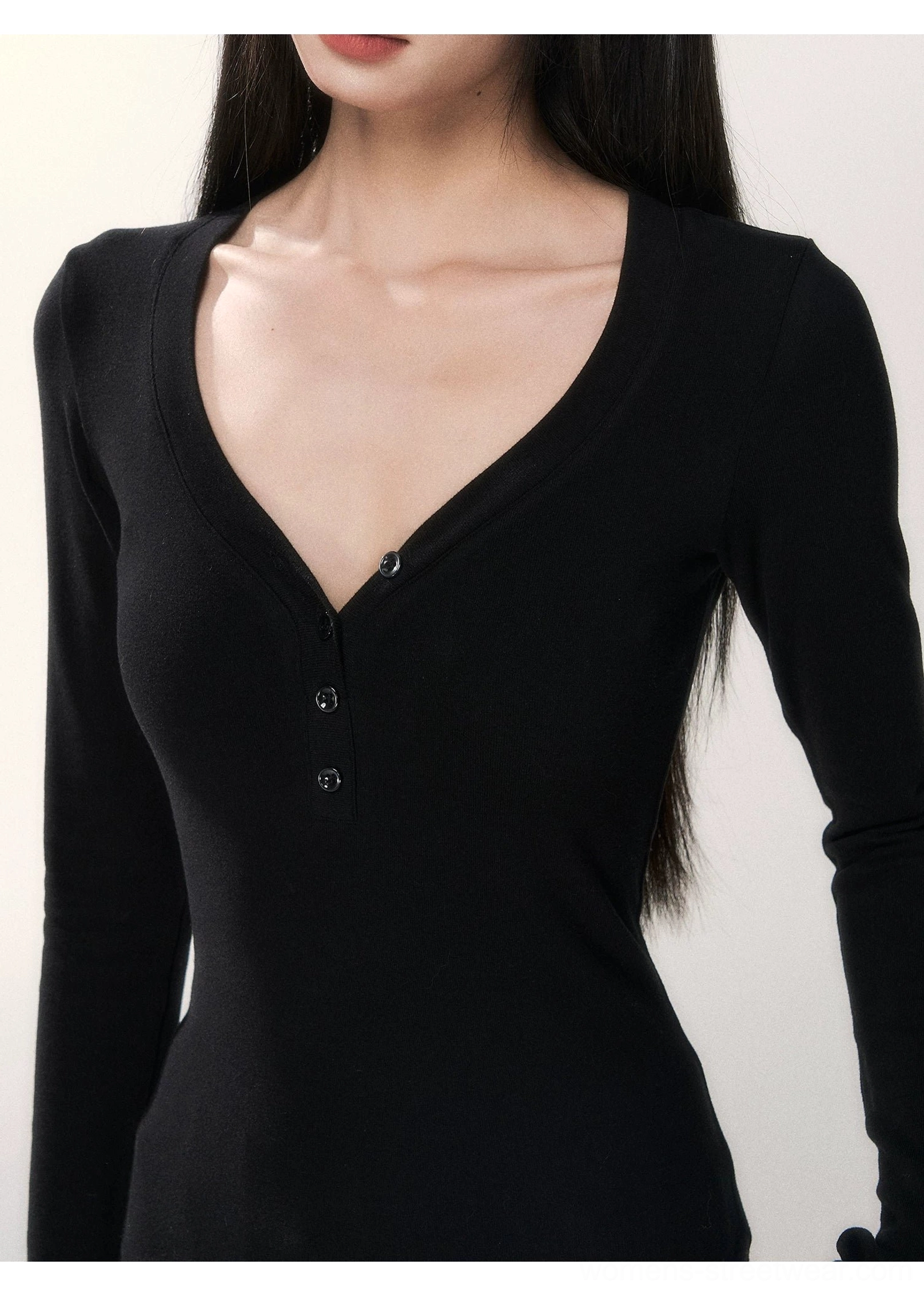 Close-up view of black deep V-neck henley top featuring a short placket and tonal round buttons on smooth knit fabric