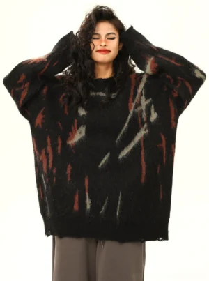 Black distressed abstract graffiti oversized streetwear sweater worn with gray wide-leg trousers front view