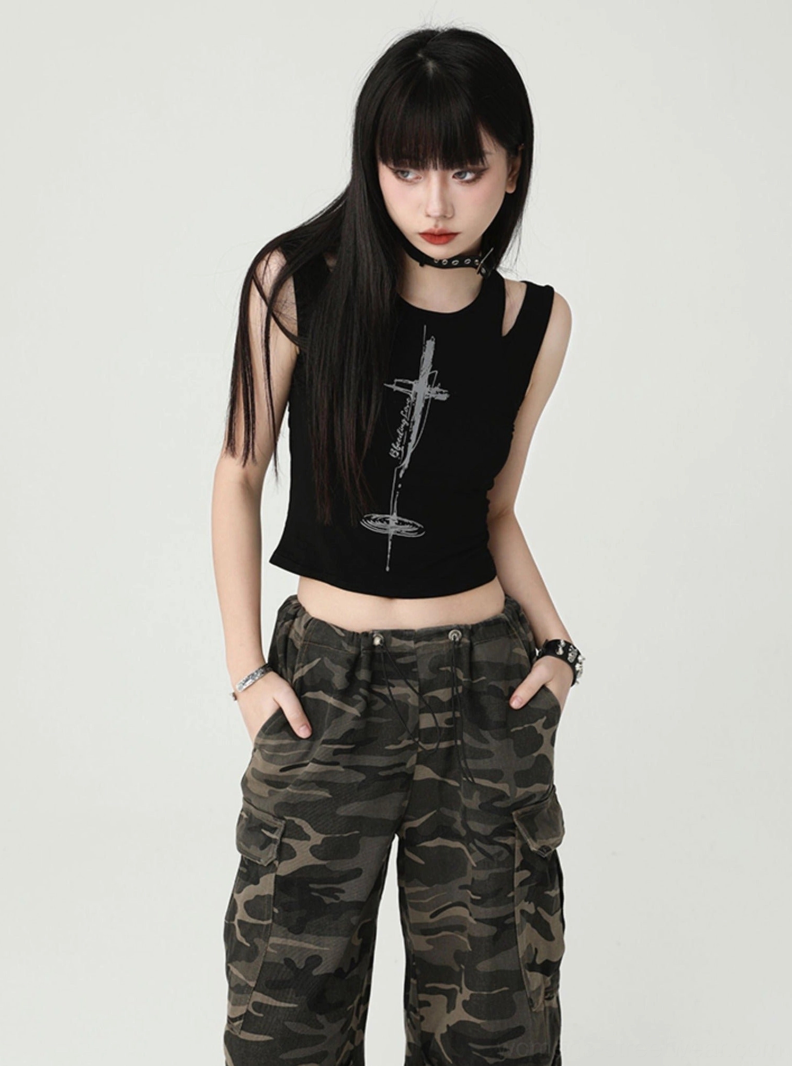 Black sleeveless cropped tank top with distressed cross graphic, shoulder cutouts, choker styling, and alternative women's streetwear details