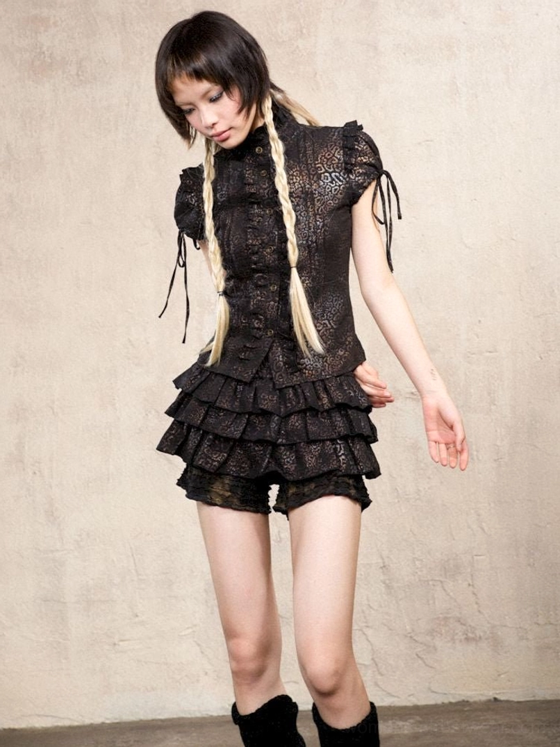 Black distressed gothic ruffle skort pants styled with a drawstring ruffle sleeve top in alternative streetwear fashion