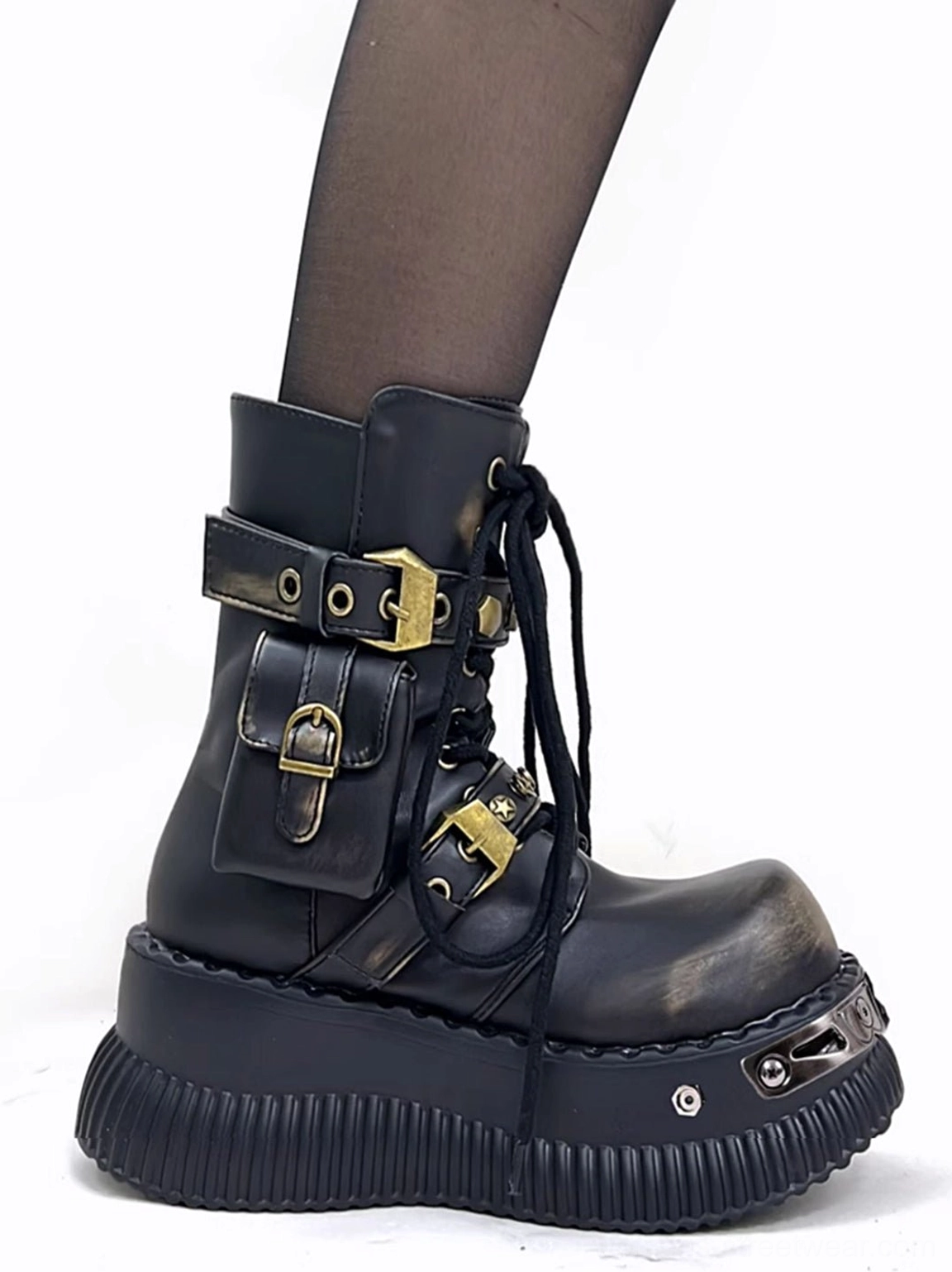 Side view of black distressed leather punk platform ankle boots worn with sheer black stockings and a ridged platform sole