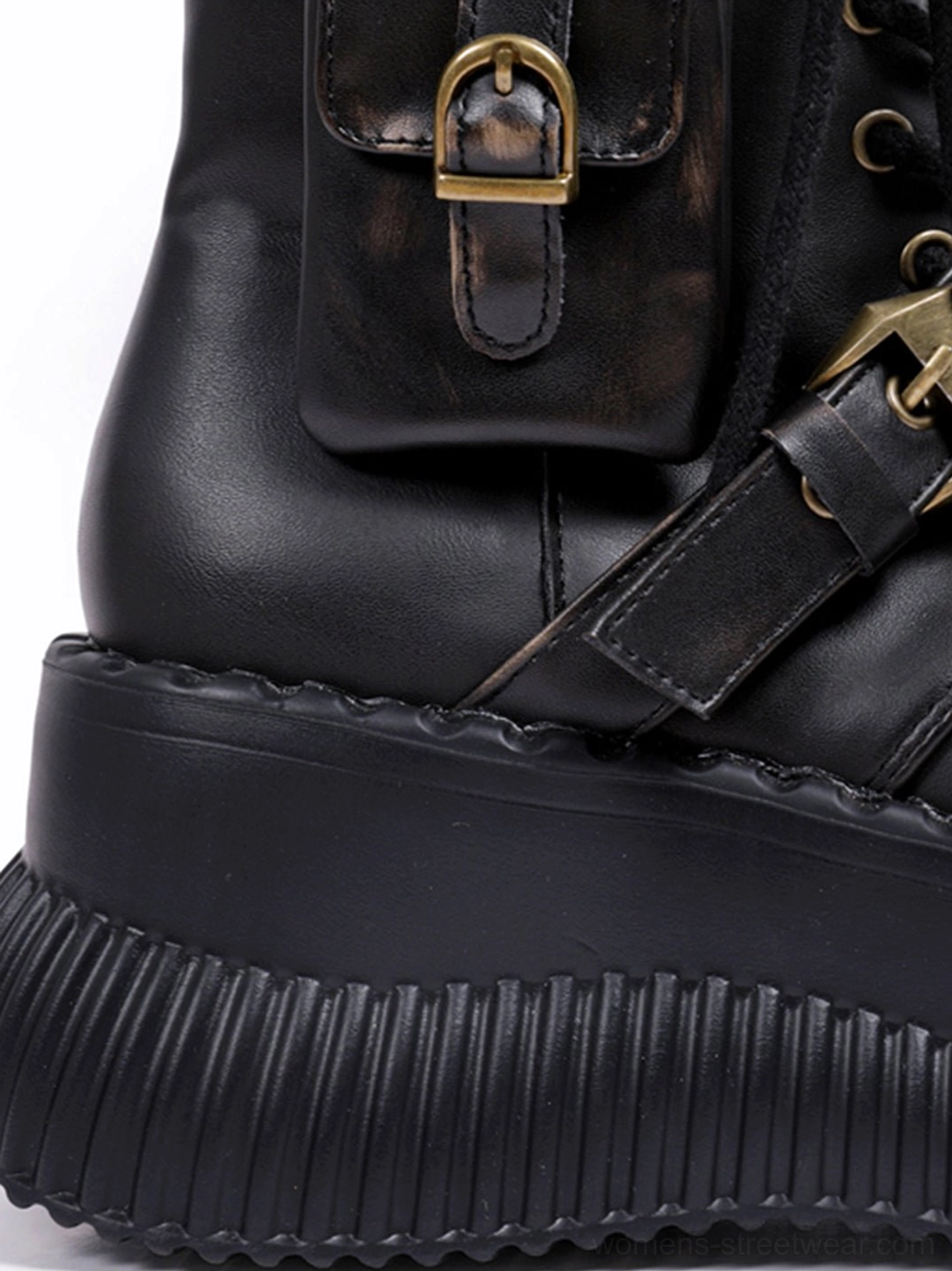 Close-up side view of black distressed platform ankle boot with thick ridged sole, vintage buckles, and industrial metal hardware