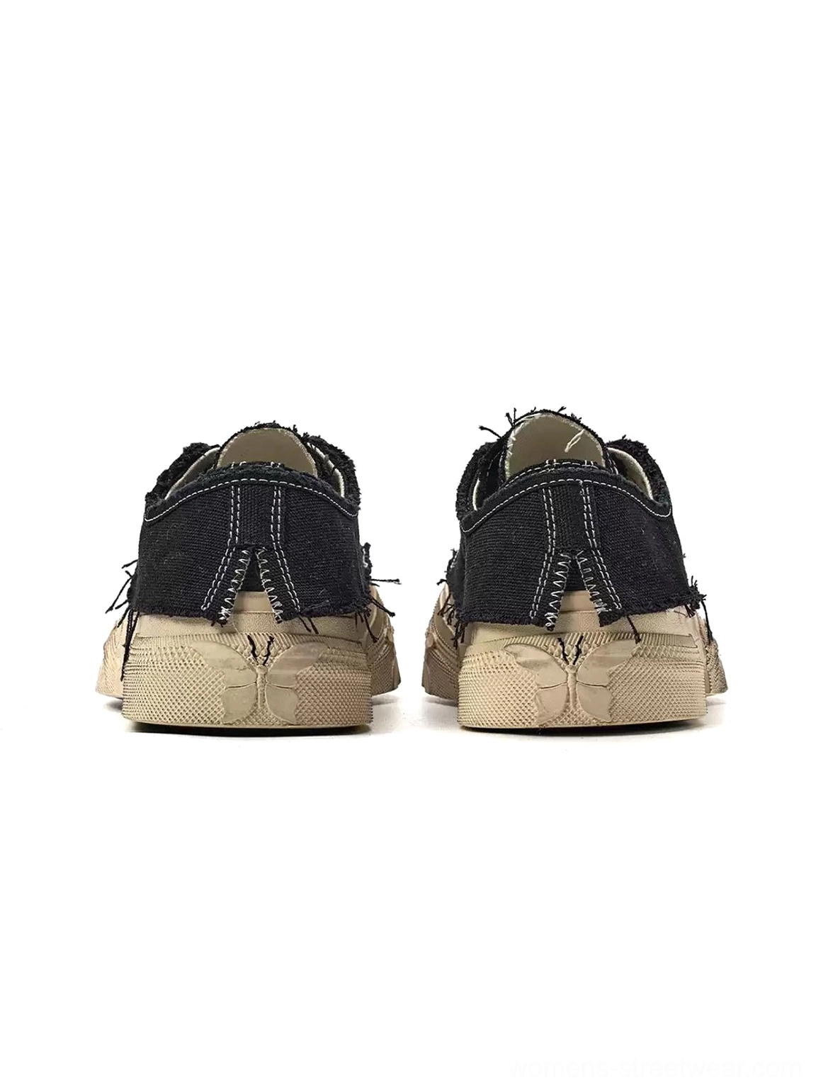 Rear view of black distressed platform canvas sneakers showing frayed heel tabs and worn off-white platform soles