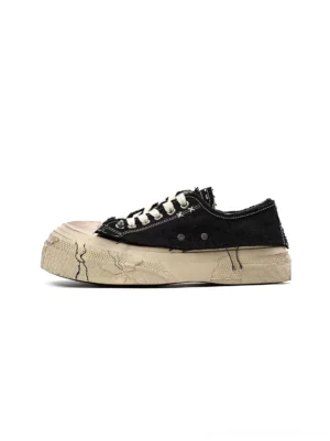 Black distressed platform canvas sneakers shown from the side with frayed edges, off-white laces, and a cracked-look rubber sole