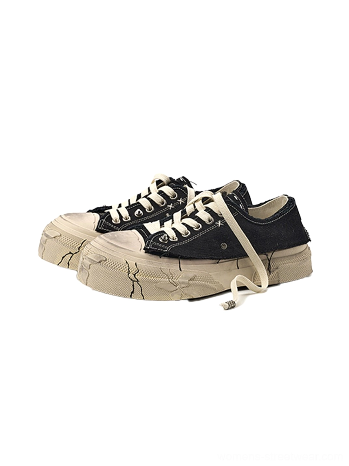 Three-quarter view of black distressed platform canvas sneakers with loose laces, frayed trim, and cracked sole detailing