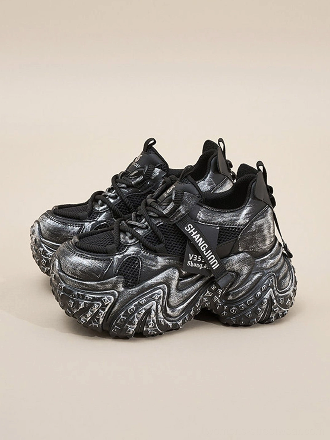 Multiple pairs of black distressed platform dad sneakers with layered technical uppers and bold chunky outsoles