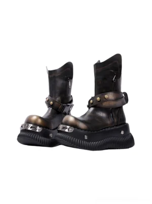 Black distressed punk platform ankle boots with round toes, studded ankle straps, metal toe plates, and ridged platform soles shown from a front three-quarter angle