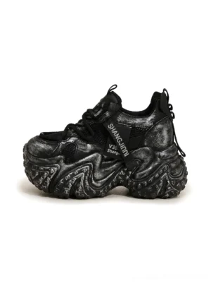 Black distressed sculptural platform dad sneakers with layered mesh upper and marbled chunky sole front side view