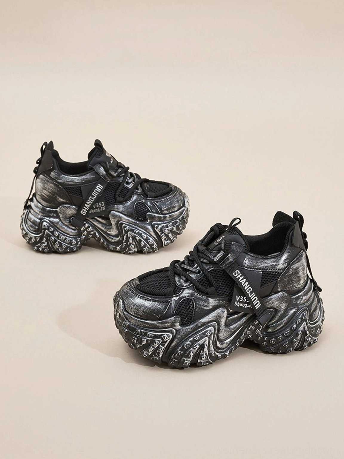 Black distressed sculptural platform sneakers side view showing lace-up closure textured upper and heel pull tab