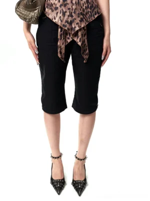 Woman wearing black distressed studded slingback pumps with a leopard print top and cropped black pants in a Y2K streetwear outfit