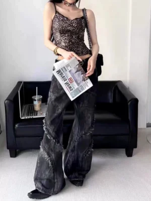 Female model wearing black distressed wide-leg flared jeans with frayed seam details and vintage washed finish in a Y2K streetwear outfit
