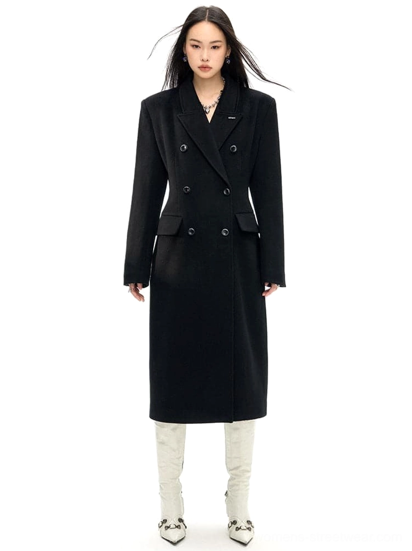 Black double-breasted wool long coat with slim waist tailoring shown in a full front studio view