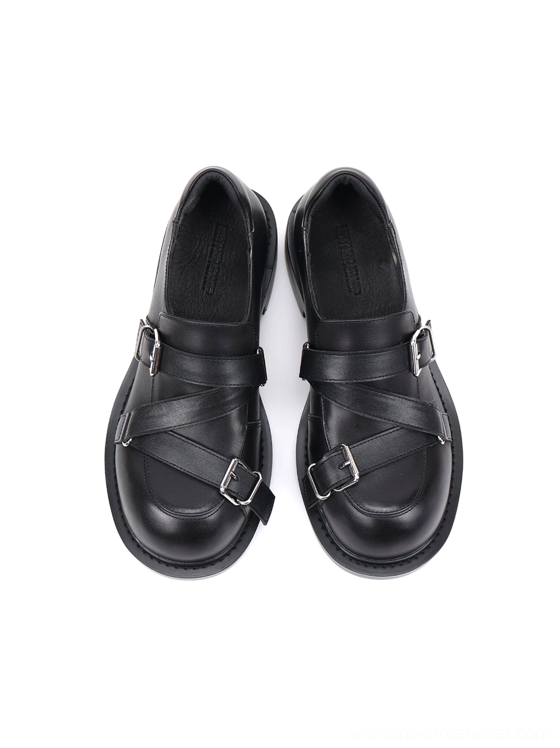 Top-down studio view of black double-buckle loafers featuring crisscross silver straps, polished uppers, and rounded toe design