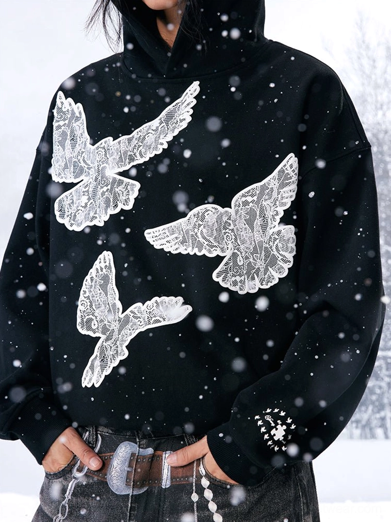 Close-up product view of a black dove graphic hoodie with snow details, relaxed sleeves and subtle cuff finishing