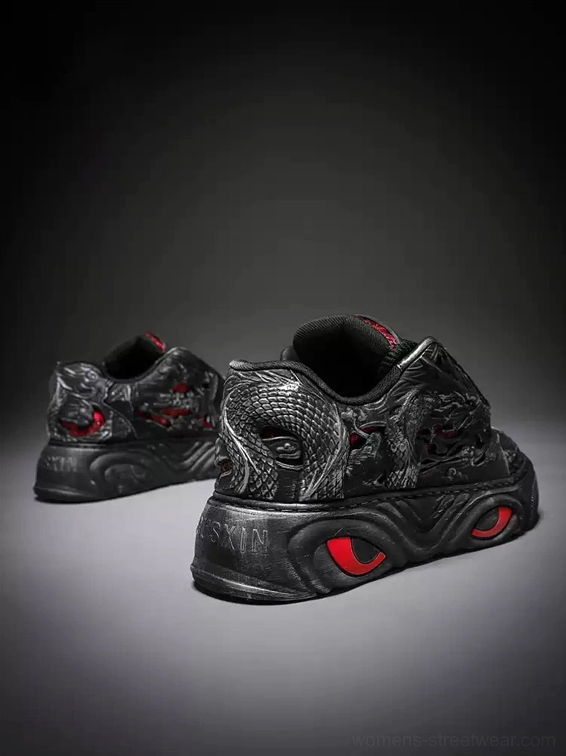 Rear view of black dragon relief chunky platform sneakers showing embossed heel details, red circular sole accents, and a low-top silhouette