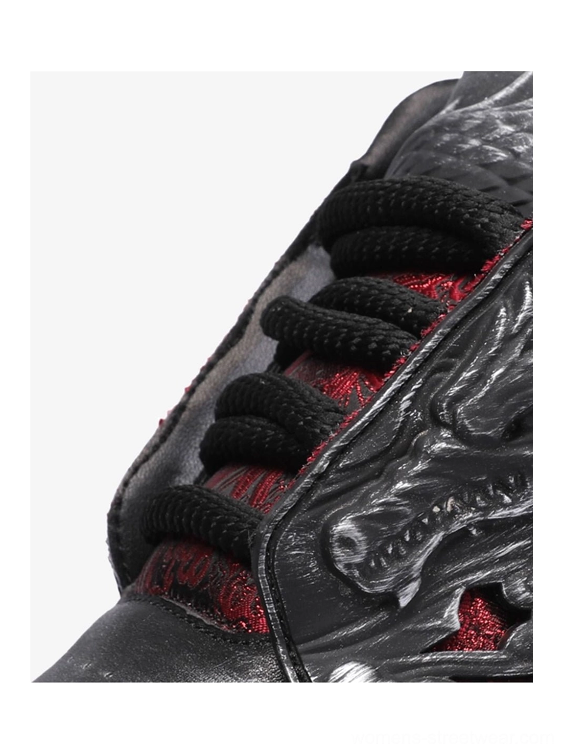 Close-up top view of black dragon relief platform sneakers with thick black laces, red underlay, textured embossed upper, and visible footbed