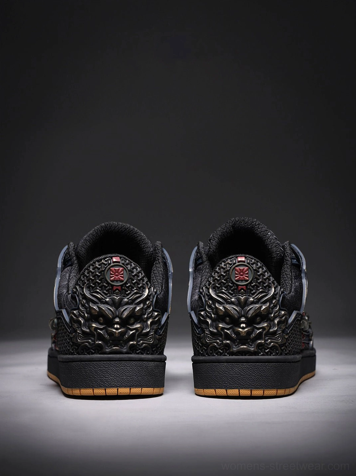 Rear view of black dragon sneakers showing bronze heel dragon ornaments, red emblems, and gum rubber soles