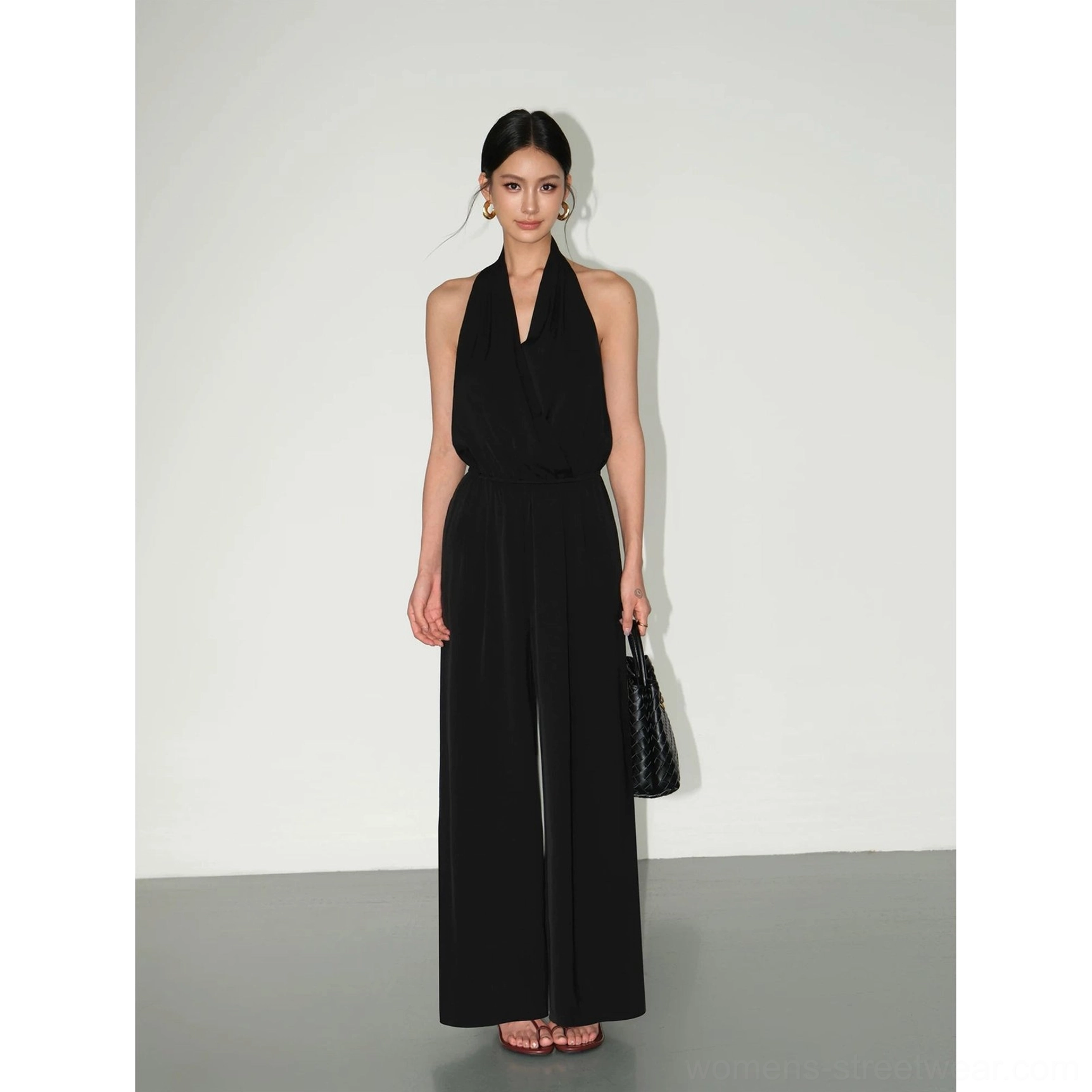 Black draped halter wide-leg jumpsuit for minimalist streetwear, evening styling, and modern city looks